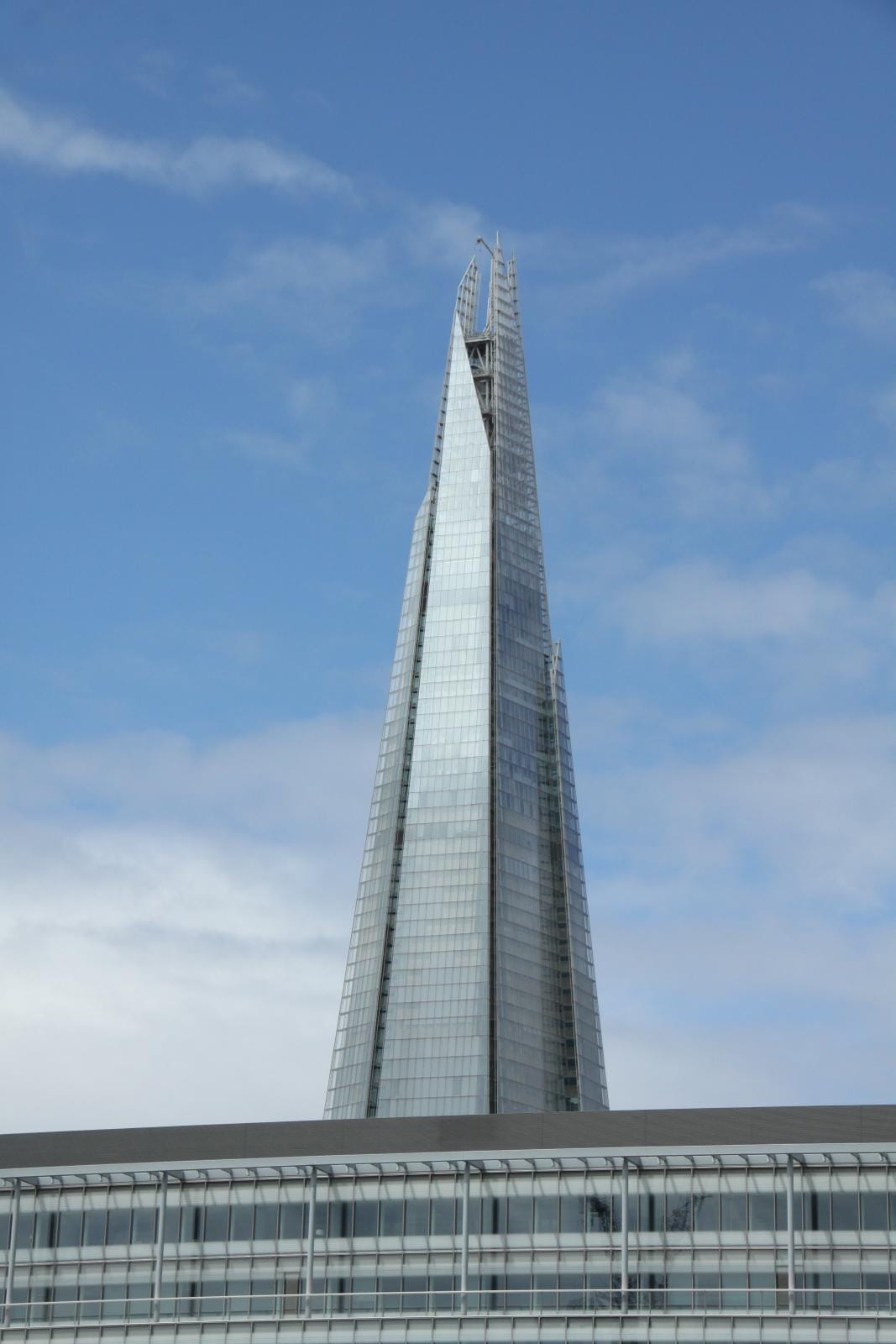 The glass façade of the Shard in London against a blue sky
